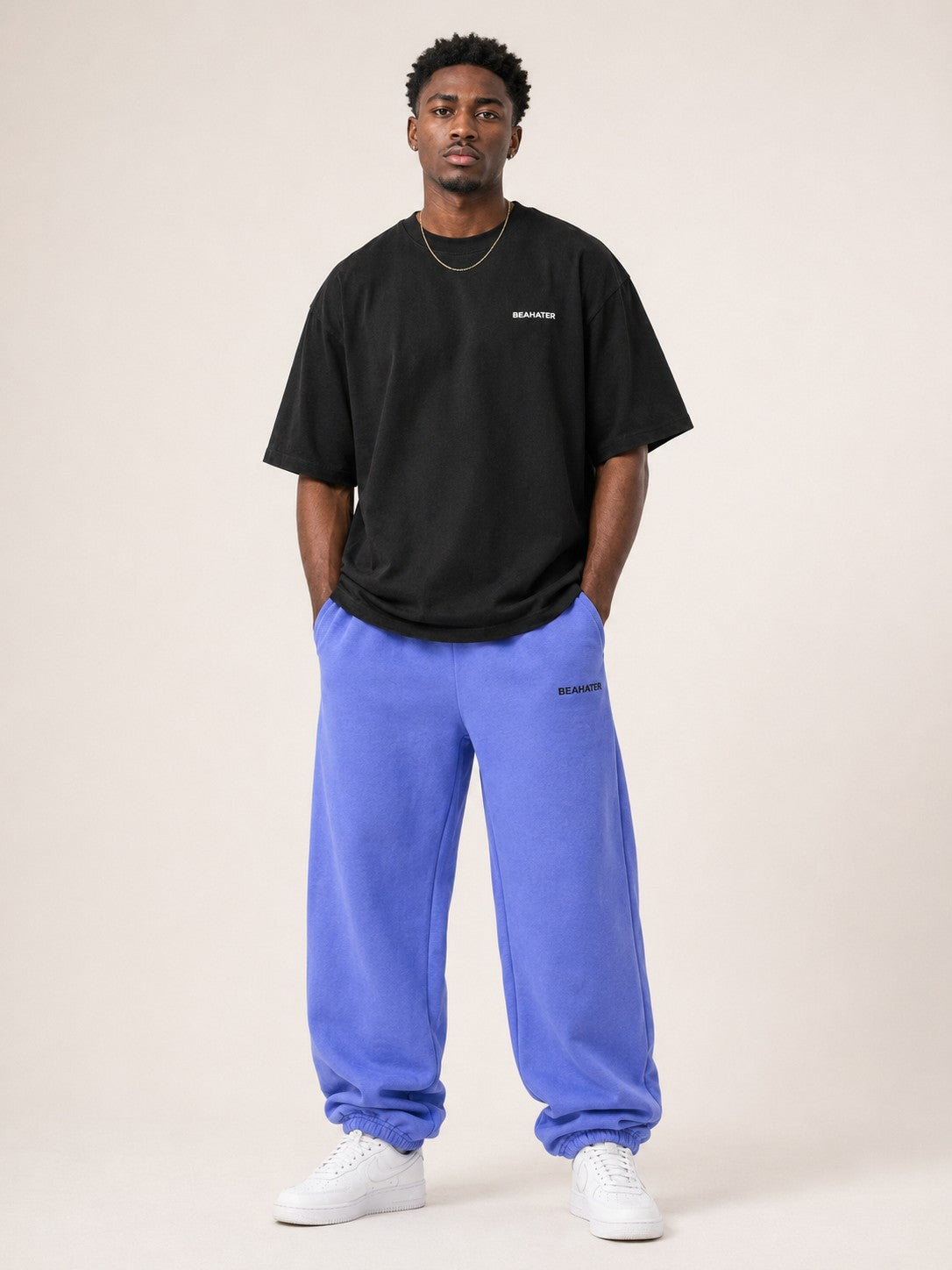 Oversized T-Shirt Schwarz Herren von vorne am Model mit baggy blauer Jogginghose und weissen Sneakern