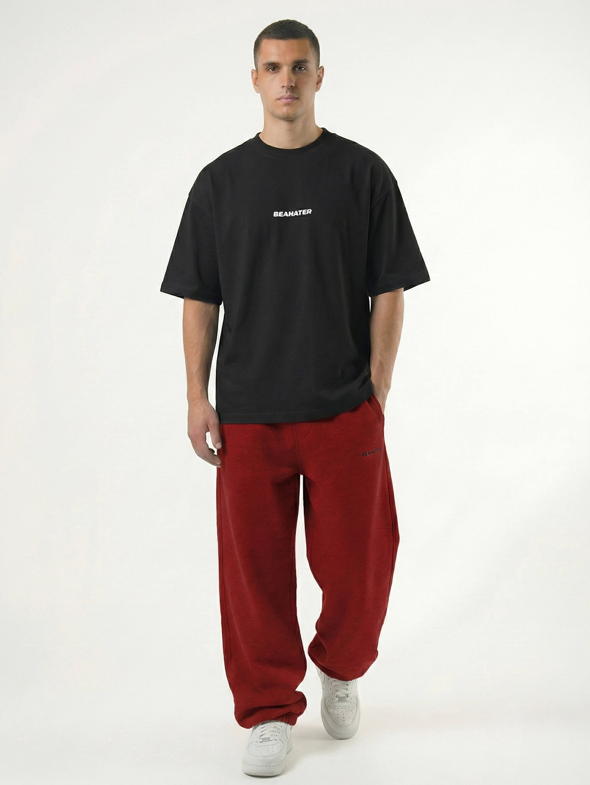 Model trägt die Baggy Jogger Wine Red im weiten Relaxed Fit mit schwarzem Oversize T-Shirt von Beahater