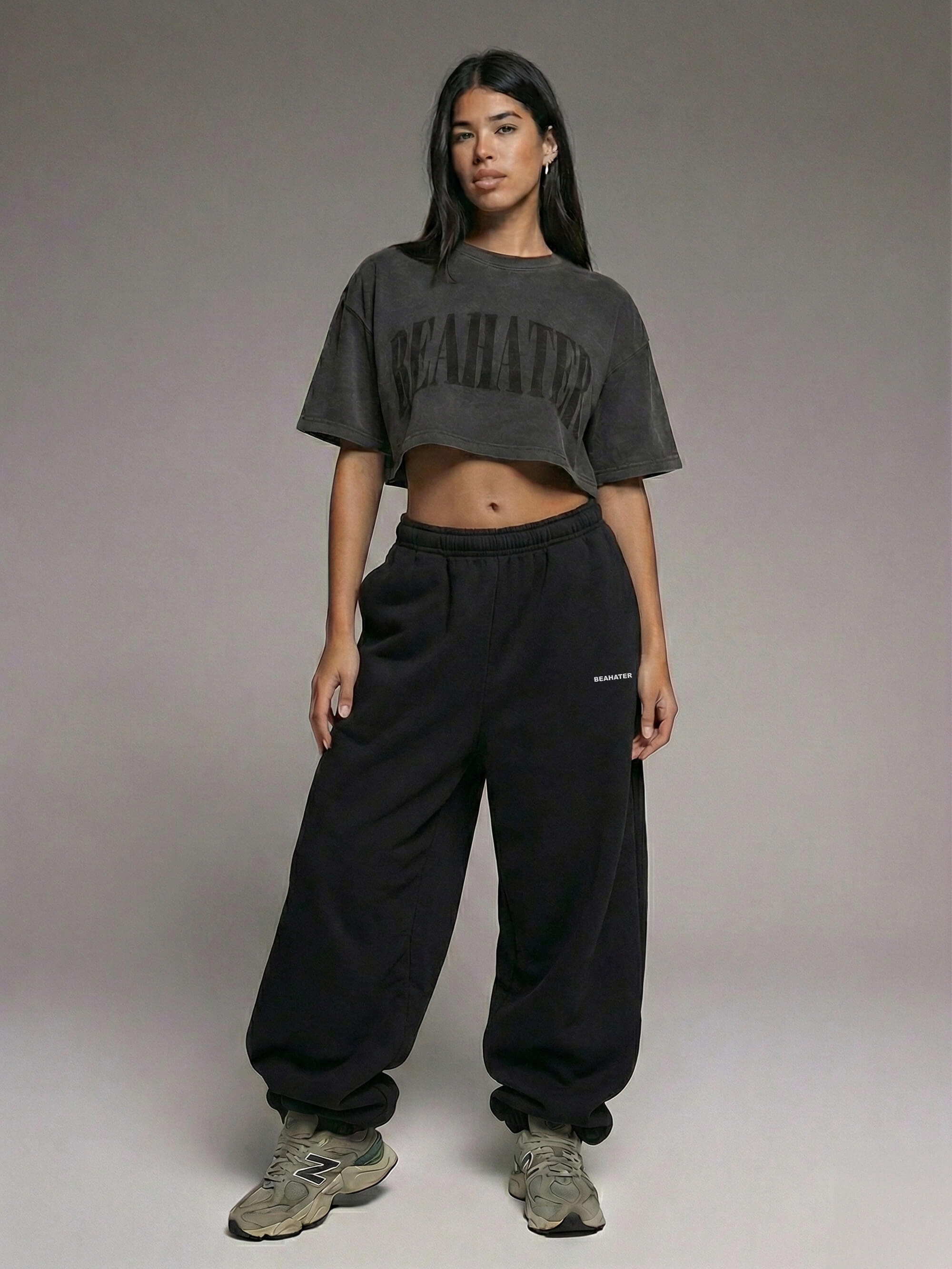Model trägt Baggy Jogger Sweatpants in Black und ein weißes Oversize T Shirt auf weißem Hintergrund, Frontansicht im entspannten Streetwear Look