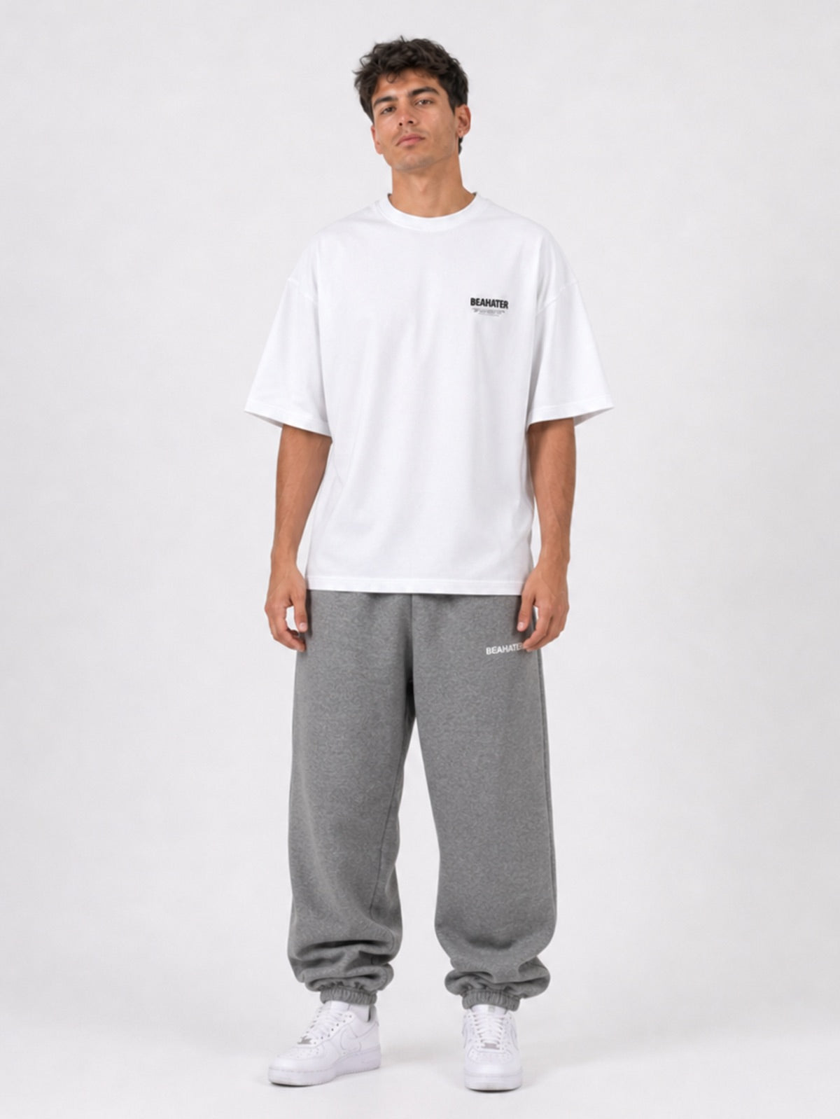 Frost Grey Baggy Jogger getragen mit weißem Oversized T-Shirt und Air Force 1, Frontansicht im Studio