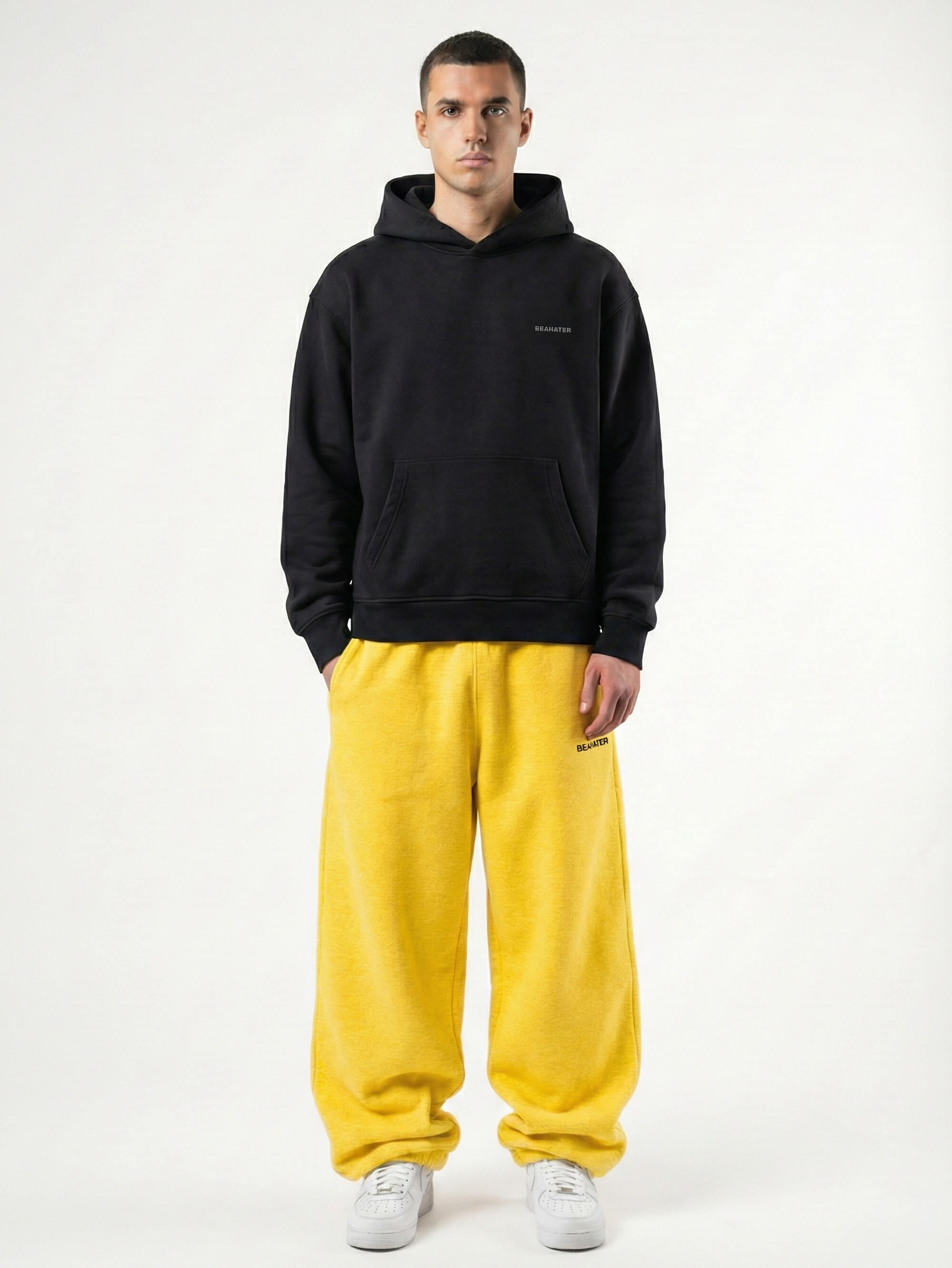 Baggy Jogger Sweatpants in Honey Yellow an einem männlichen Model, Frontansicht auf weißem Hintergrund, hochwertiger French Terry Stoff mit elastischem Bund und relaxed Streetwear Fit