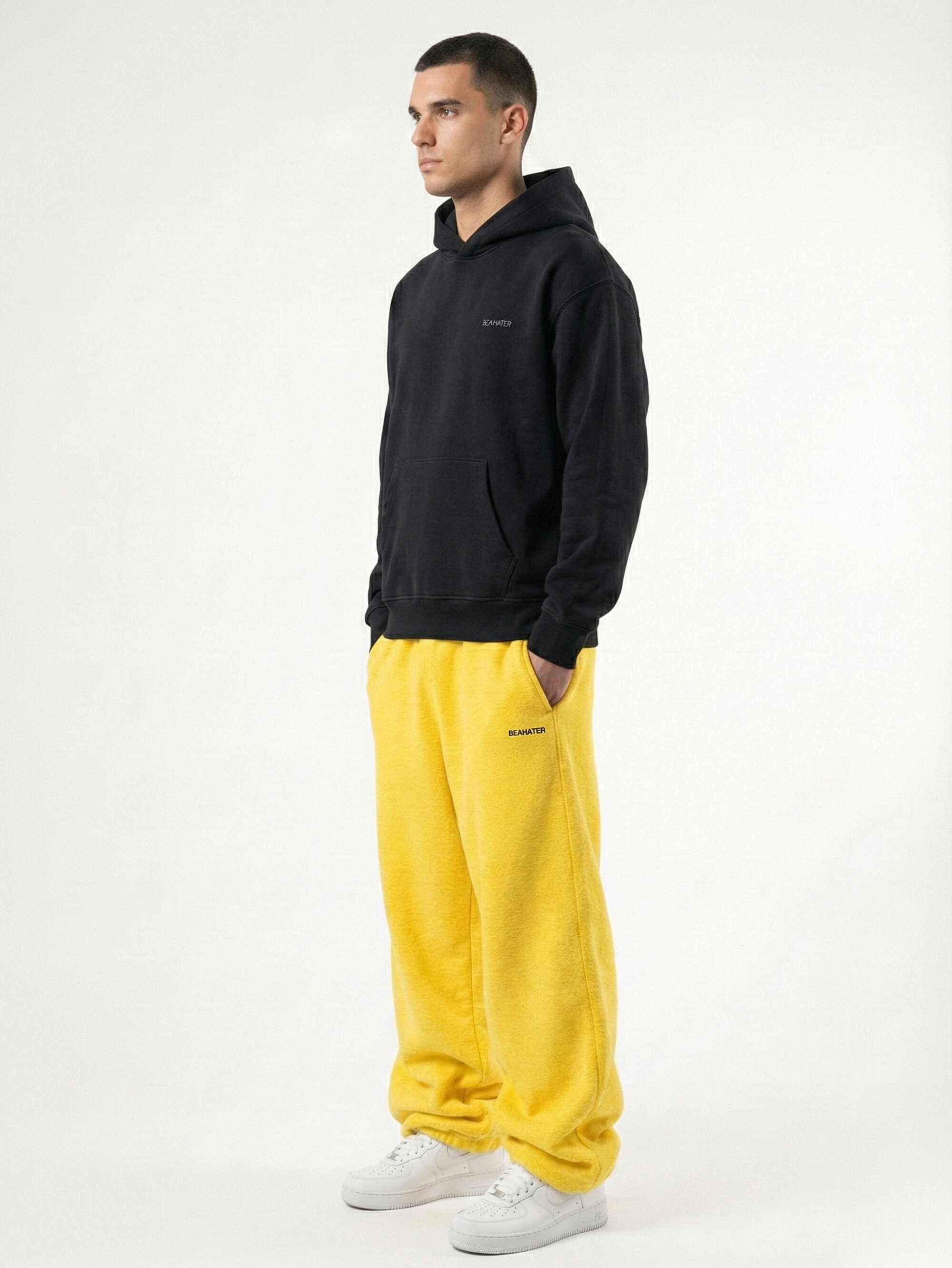 Baggy Jogger Sweatpants in Honey Yellow an einem männlichen Model, Seitenansicht auf weißem Hintergrund, hochwertiger French Terry Stoff mit elastischem Bund und relaxed Streetwear Fit