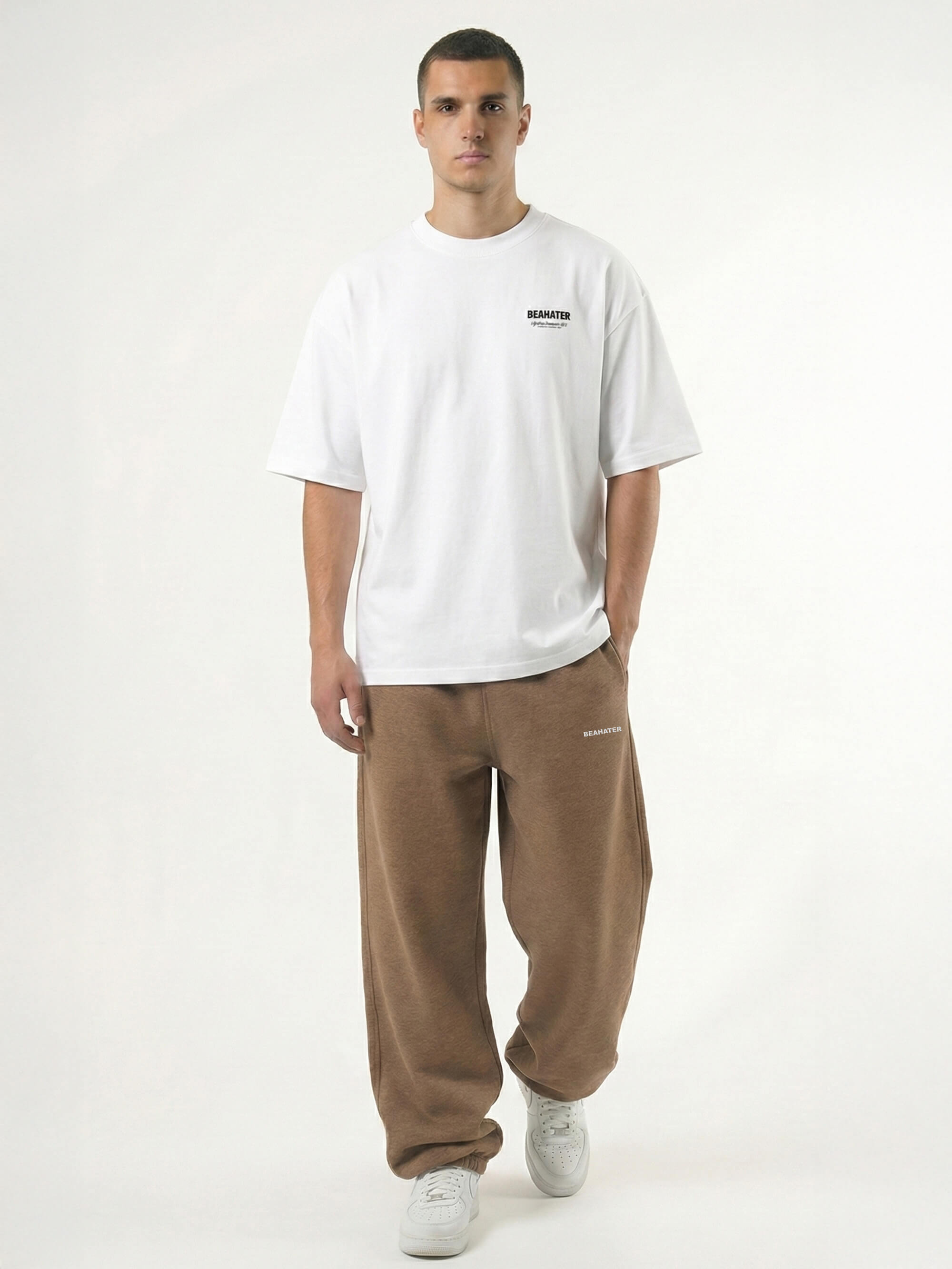 Baggy Jogger Sweatpants in Mocha Brown an einem männlichen Model, Frontansicht auf weißem Hintergrund, lockerer Streetwear Fit mit elastischem Bund aus Midweight French Terry