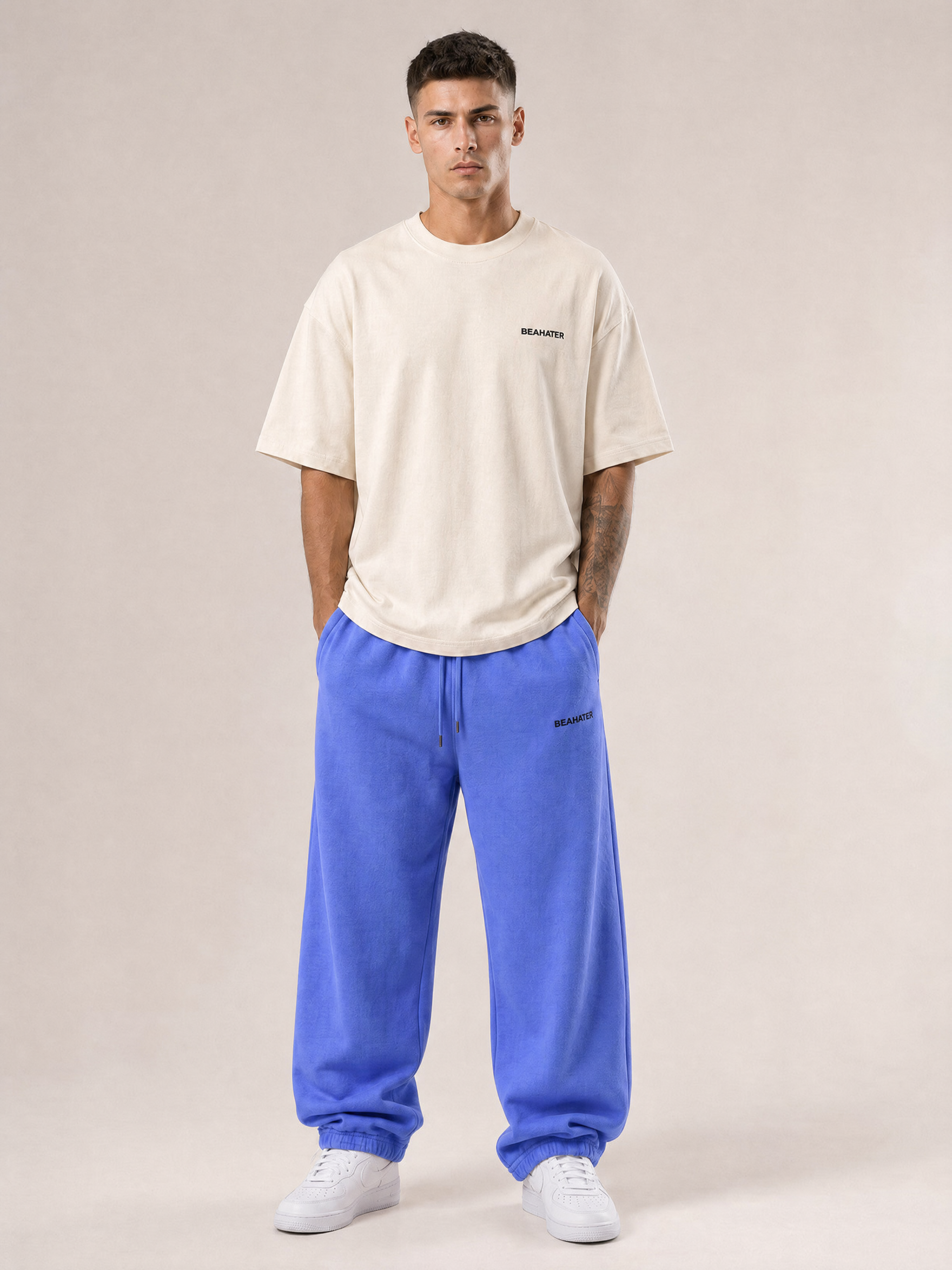 Baggy Jogger lila, French Terry 340 g/m², an männlichem Model, Frontansicht, Off-White Tee, weiße Sneaker