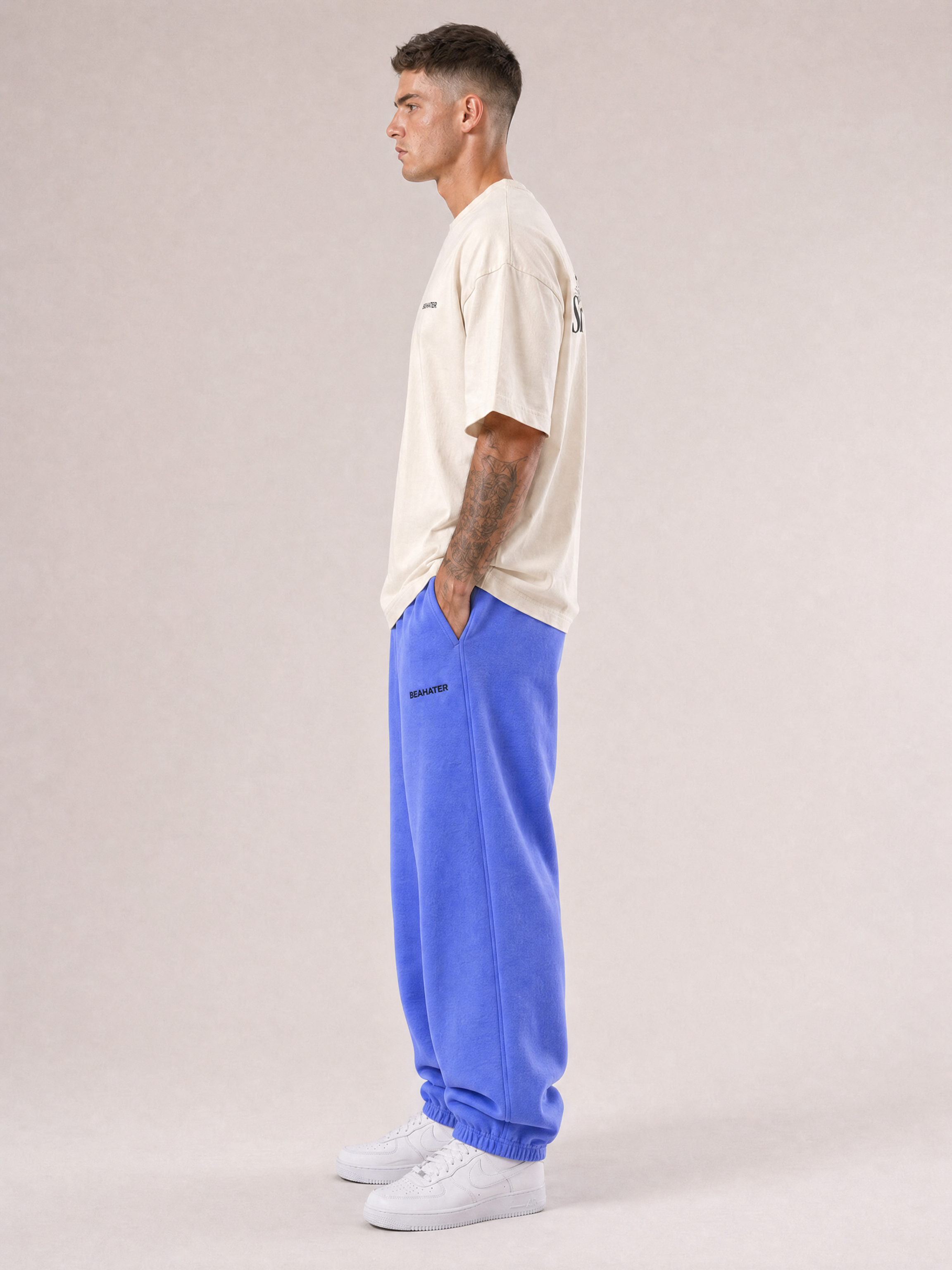 Baggy Jogger lila an männlichem Model, Seitenansicht, weiter baggy Schnitt, weiße Sneaker