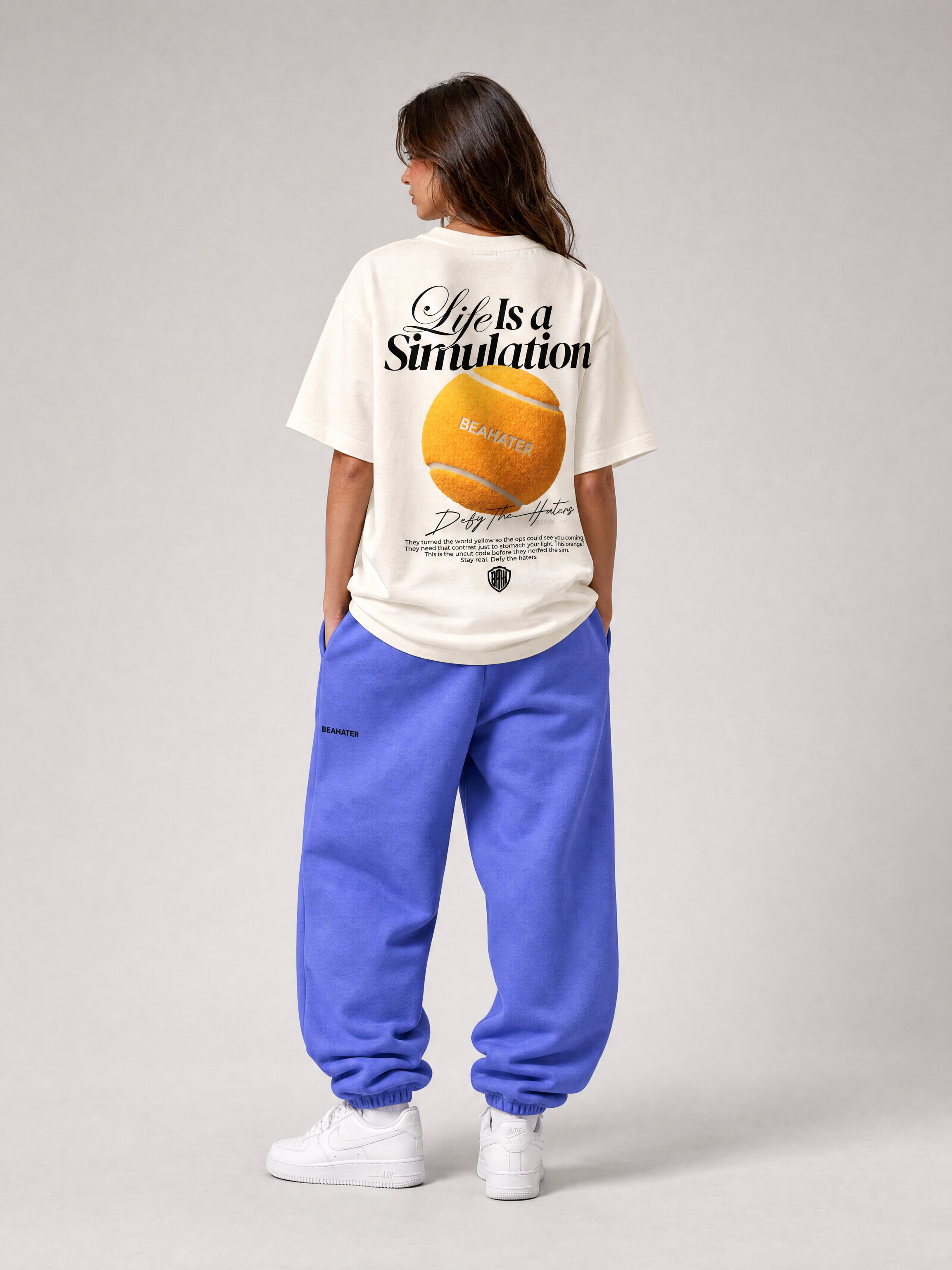 Baggy Jogger lila an weiblichem Model, Rückansicht, Tee mit Simulation Backprint, weiße Sneaker
