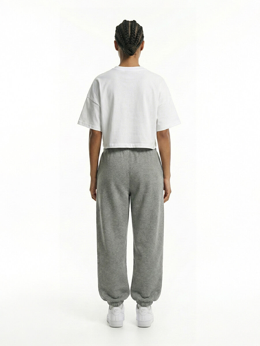 Model zeigt Rückansicht des weißen Cropped Oversized T-Shirts von BEAHATER