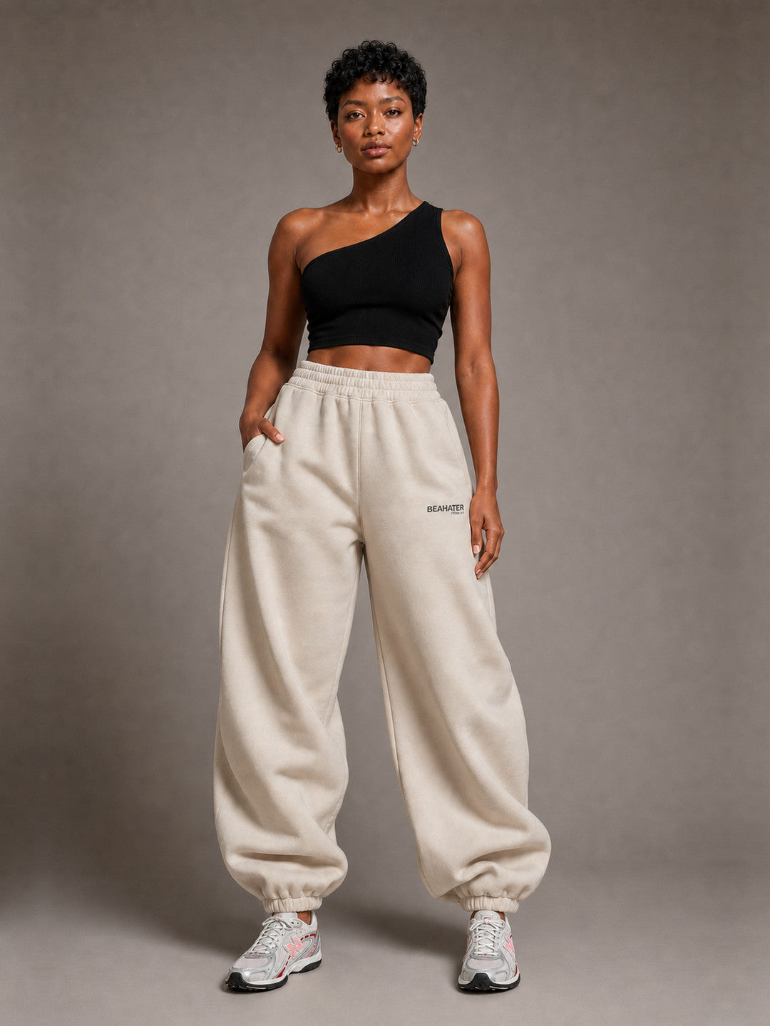 BEAHATER Relaxed Sweatpants Beige im Baggy-Fit – Frontansicht mit silber-weißen Retro-Sneakern