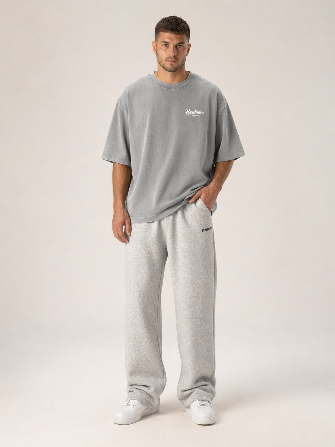 Graues Oversized T-Shirt Herren mit dezentem Script-Logo auf der Brust, Frontansicht am Model
