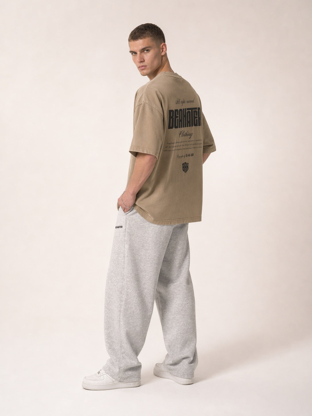 Stone-farbenes Oversized T-Shirt 3/4-Seitenansicht am Model, Boxy Fit, Schriftzug Rücken, Streetwear
