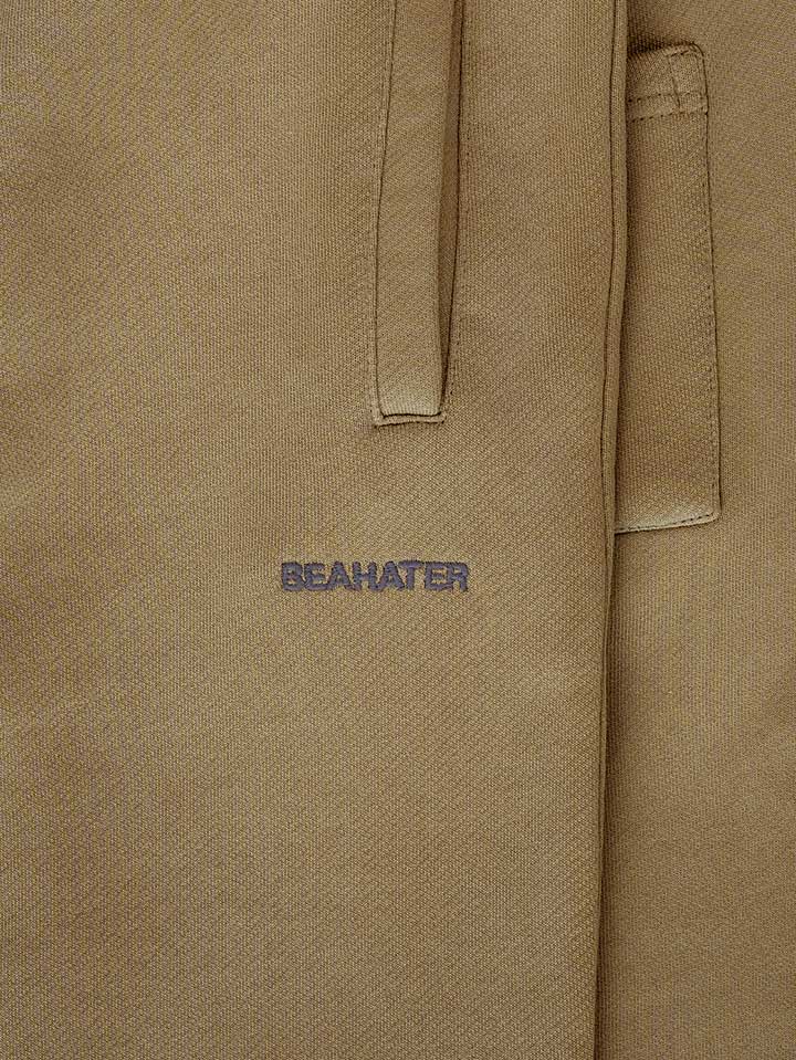 Detailaufnahme der 2D Logo-Stickerei Beahater auf Open Leg Jogger in Washed Mocha Mousse