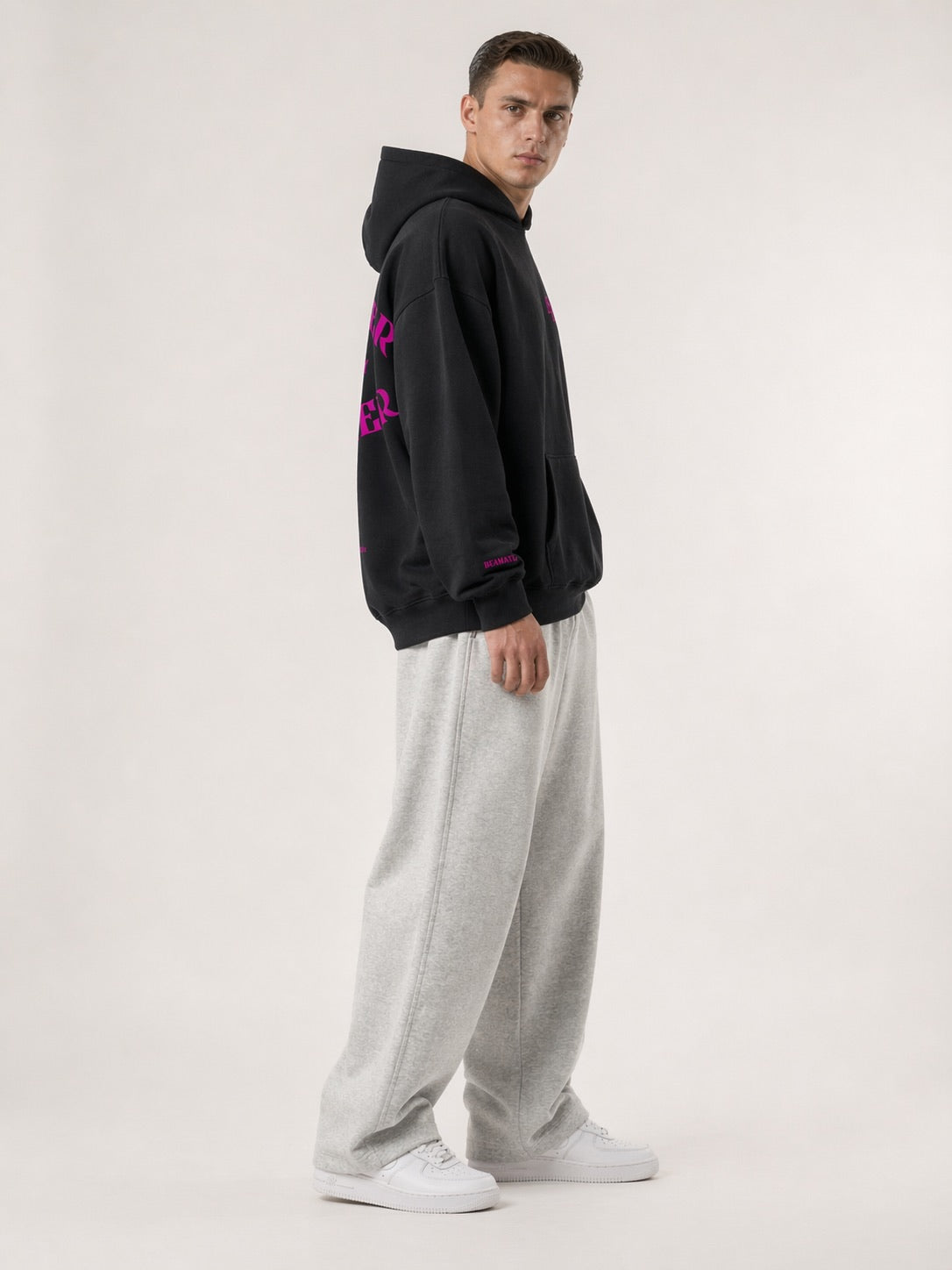 Schwarzer Heavyweight Hoodie 3/4-Seitenansicht am Model, Oversized Fit, Streetwear mit Puff-Print Detail