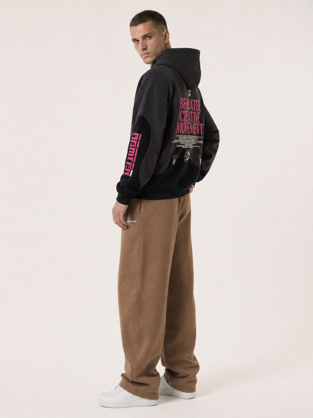 Schwarzer Zip Hoodie Oversized am Model mit Aermel-Print, Dreiviertelansicht von hinten