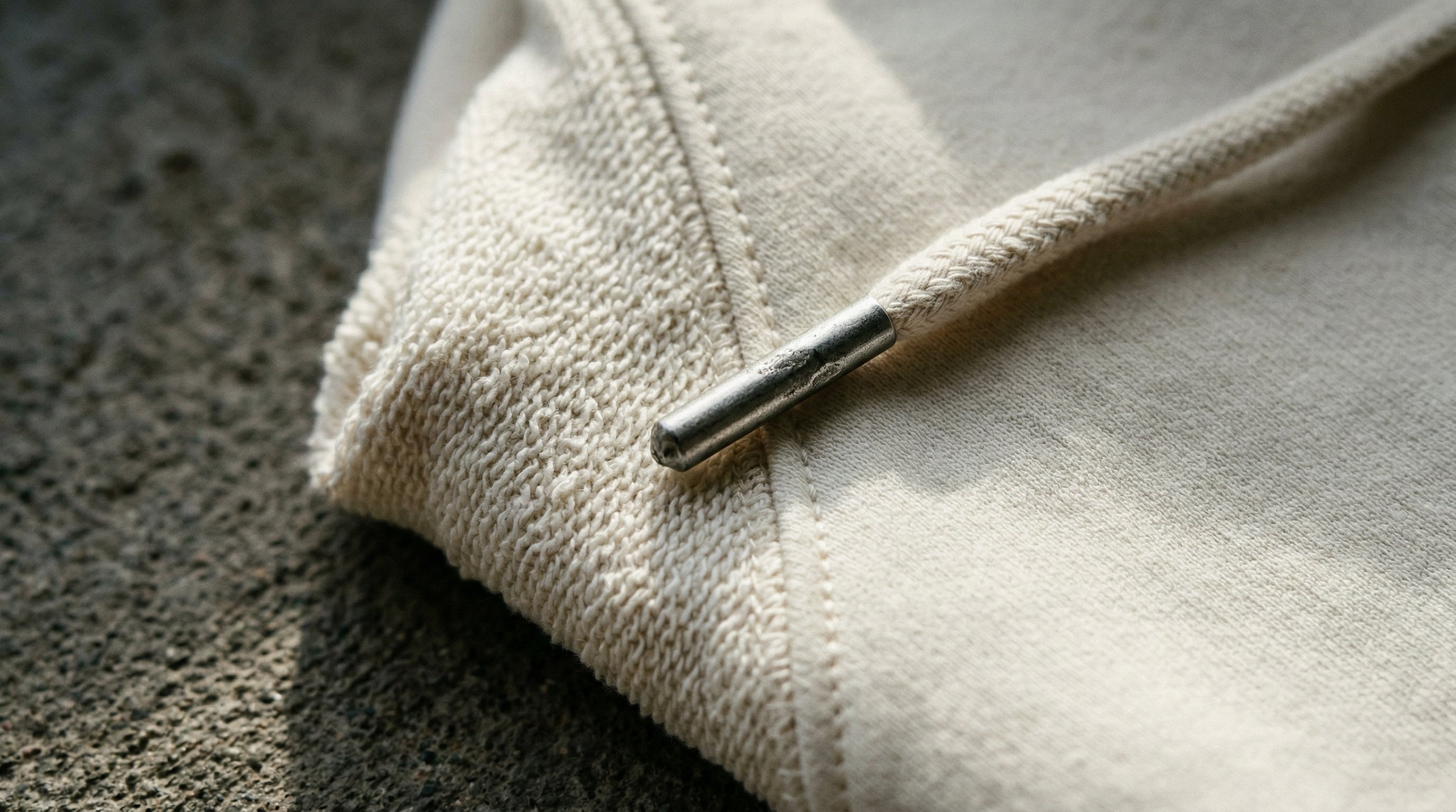 Heavyweight French Terry Hoodie Material Nahaufnahme mit Naht und Metall Drawstring Tip