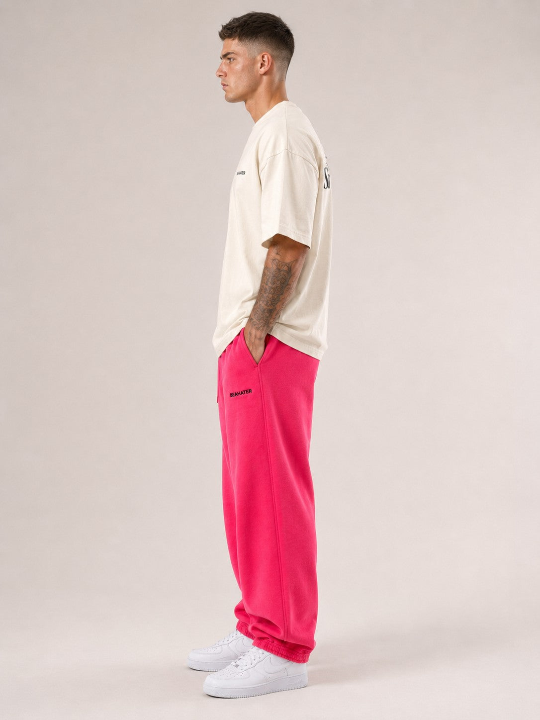 Oversized T-Shirt Off White Herren seitlich am Model, baggy Streetwear Fit mit pinker Jogginghose