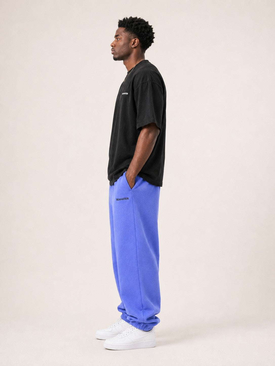 Oversized T-Shirt Schwarz Herren seitlich am Model, baggy Streetwear Fit mit blauer Jogginghose