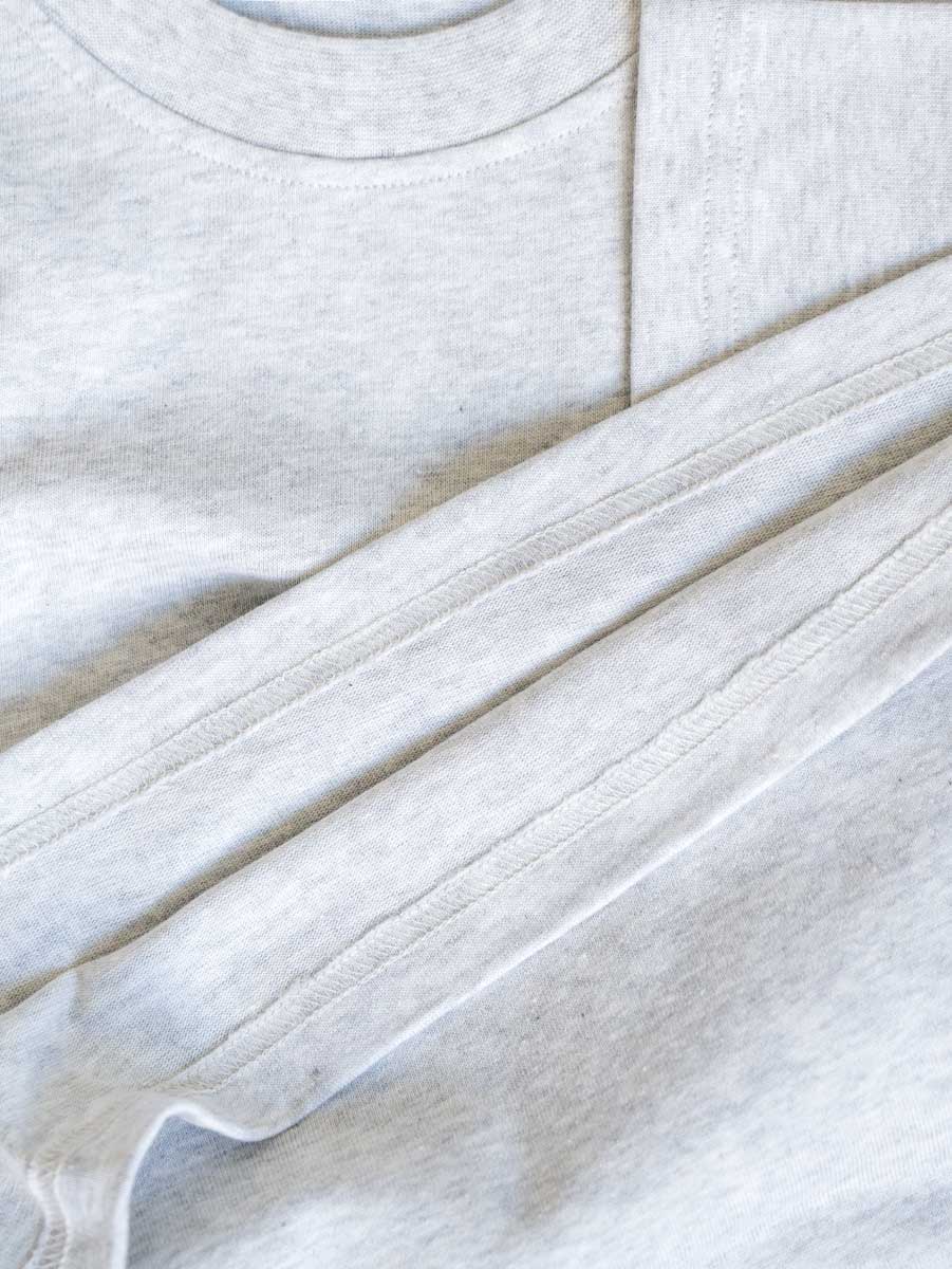 Detailaufnahme des grauen Cropped T-Shirts – hochwertige Baumwolle und doppelte Nähte im Fokus