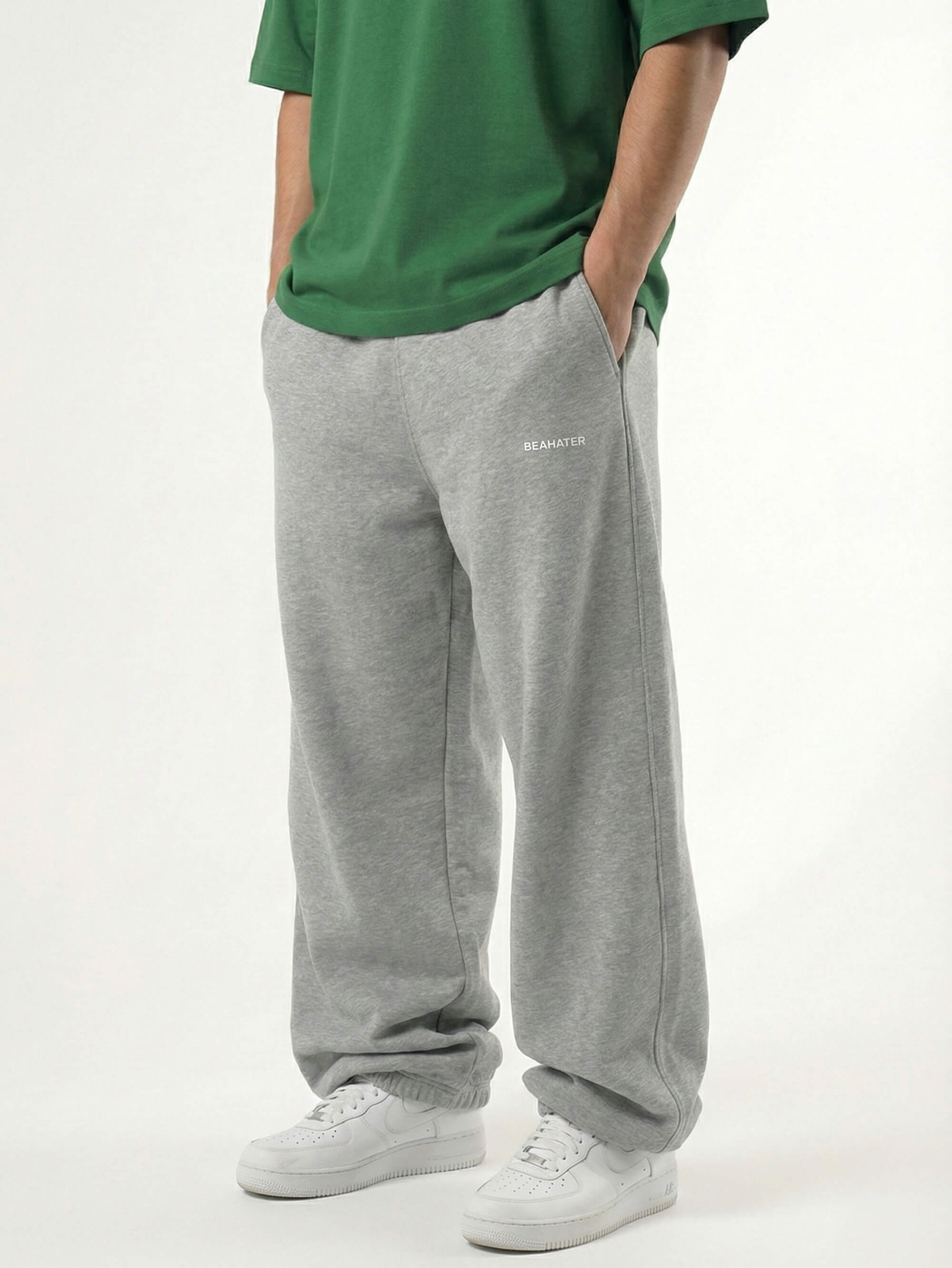 Baggy Jogger Sweatpants in Ash Grey an einem männlichen Model, Seitenansicht auf weißem Hintergrund, relaxed Streetwear Fit mit elastischem Bund