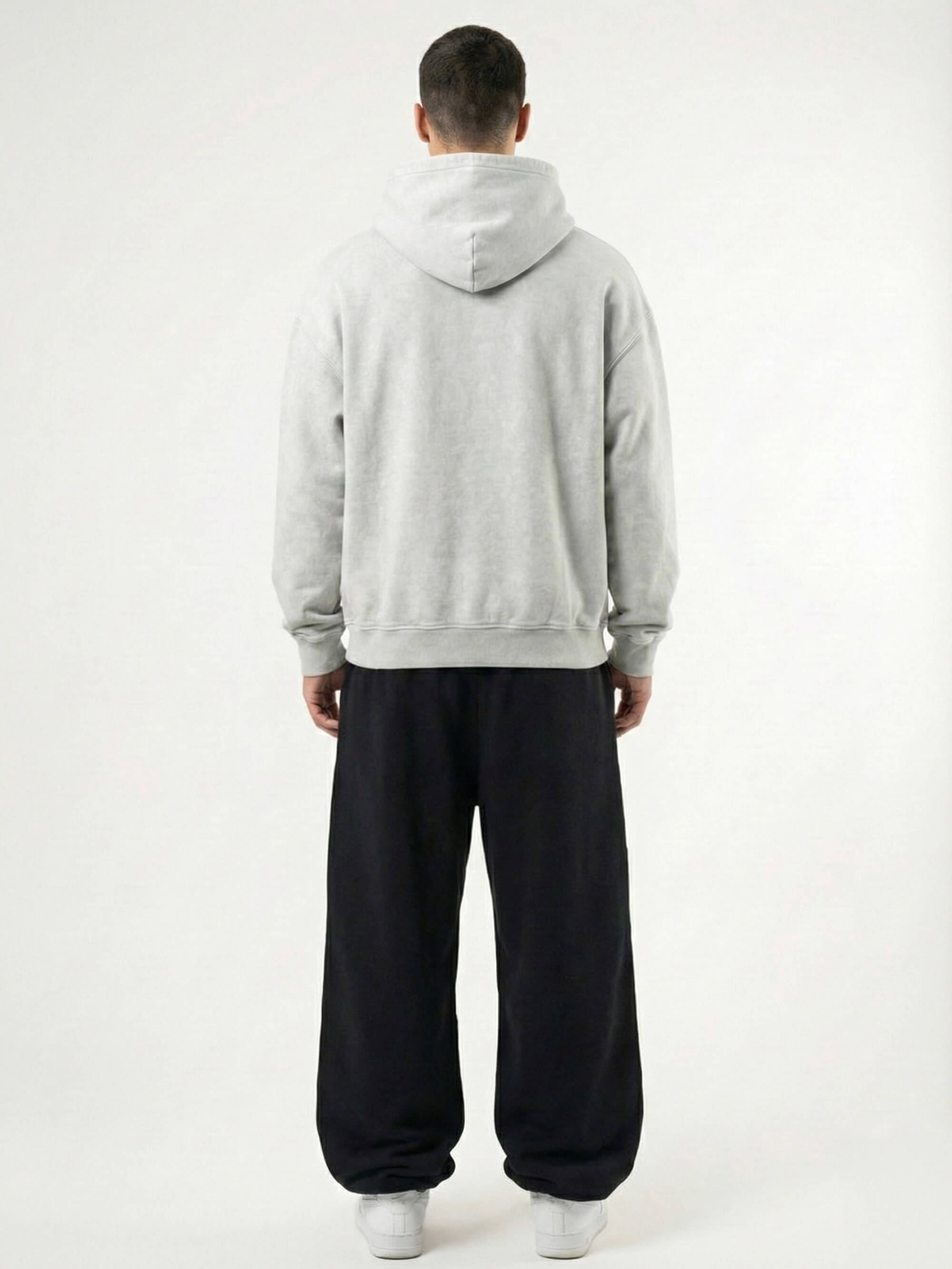Baggy Jogger Sweatpants in Ash Grey am männlichen Model, Rückansicht, weiter Baggy Fit mit elastischem Bund und weicher Stoffstruktur auf weißem Hintergrund