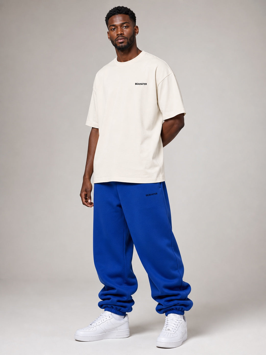 Deep Blue Baggy Jogger am Herrenmodel in Dreiviertelansicht mit Off-White T-Shirt und weißen Sneakern