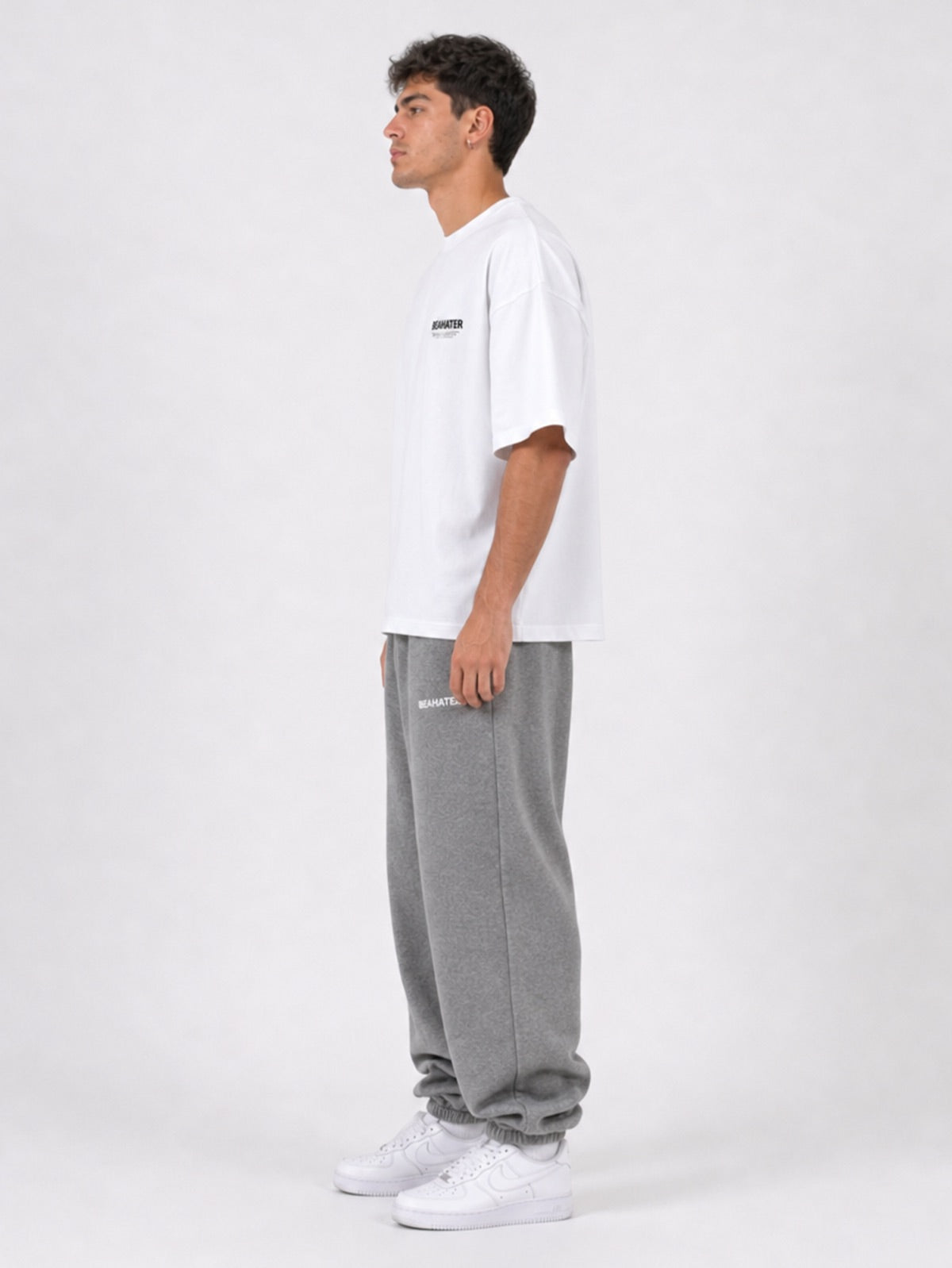 Baggy Sweatpants in Frost Grey im Seitenprofil mit Oversized T-Shirt in Weiß, Studio-Lookbook