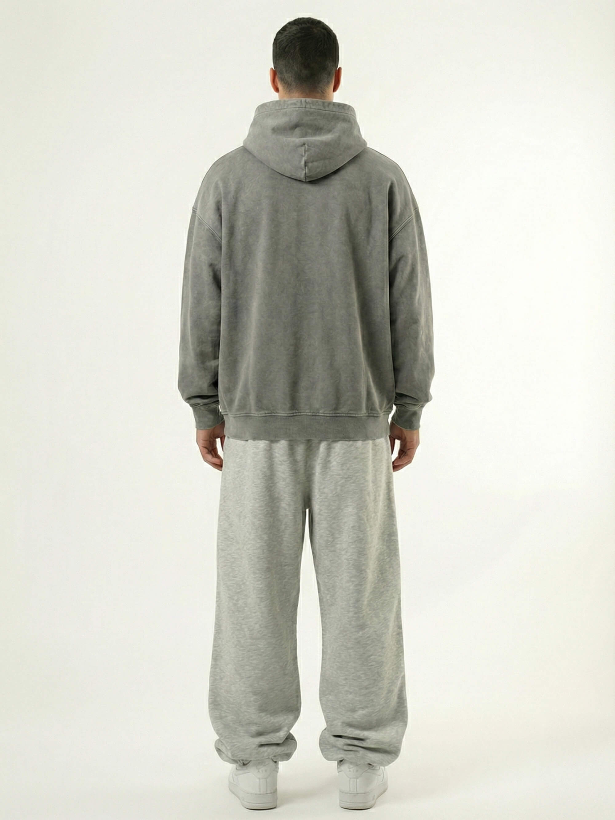 Baggy Jogger Sweatpants in Light Grey am Model in Rückansicht auf weißem Hintergrund aus French Terry mit elastischem Bund und relaxed Streetwear Fit