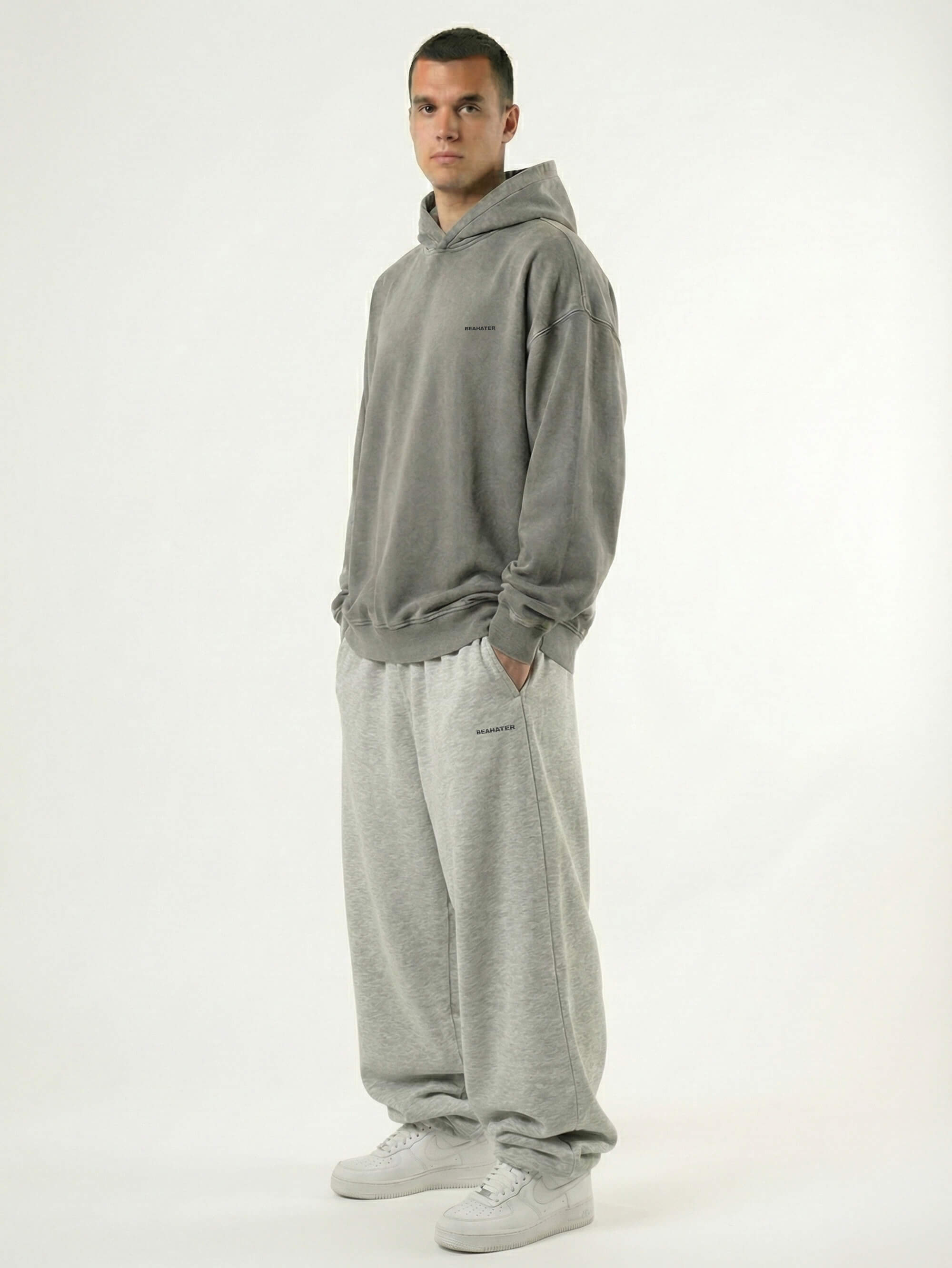 Baggy Jogger Sweatpants in Light Grey am Model in Seitenansicht auf weißem Hintergrund aus French Terry mit elastischem Bund und relaxed Streetwear Fit