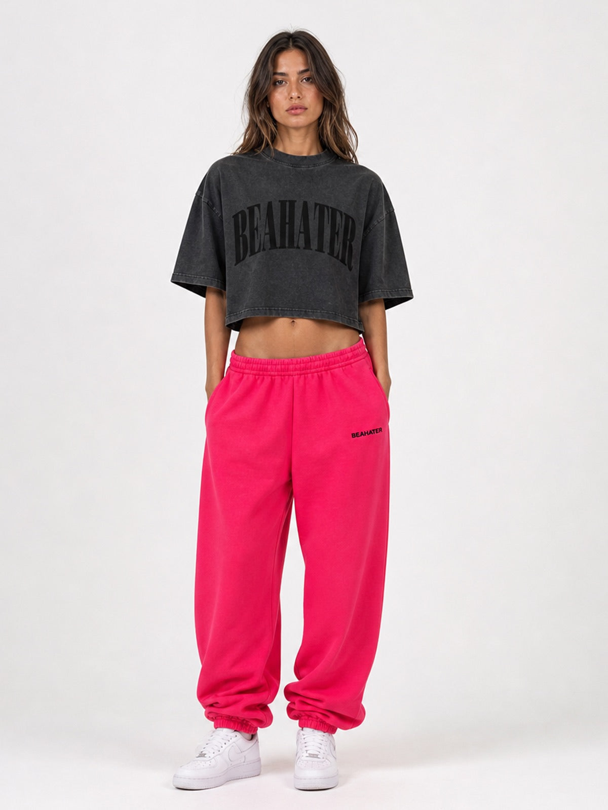 Pinke Baggy Jogger am Damen-Model in Frontansicht, Hände an der Seite mit washed Cropped Tee