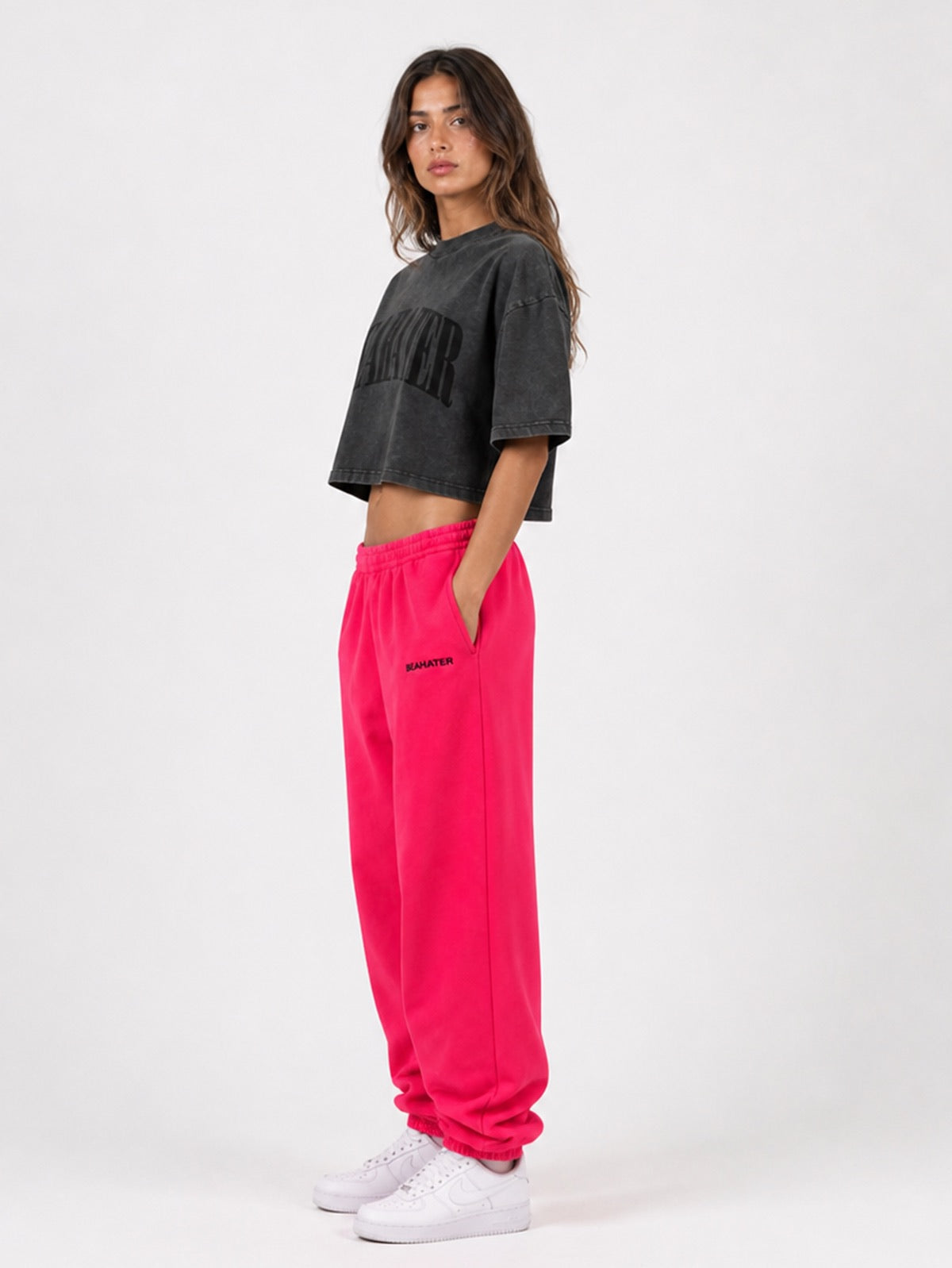 Pinke Baggy Jogger Seitenansicht am Damen-Model, Hände in den Taschen mit washed Cropped Tee