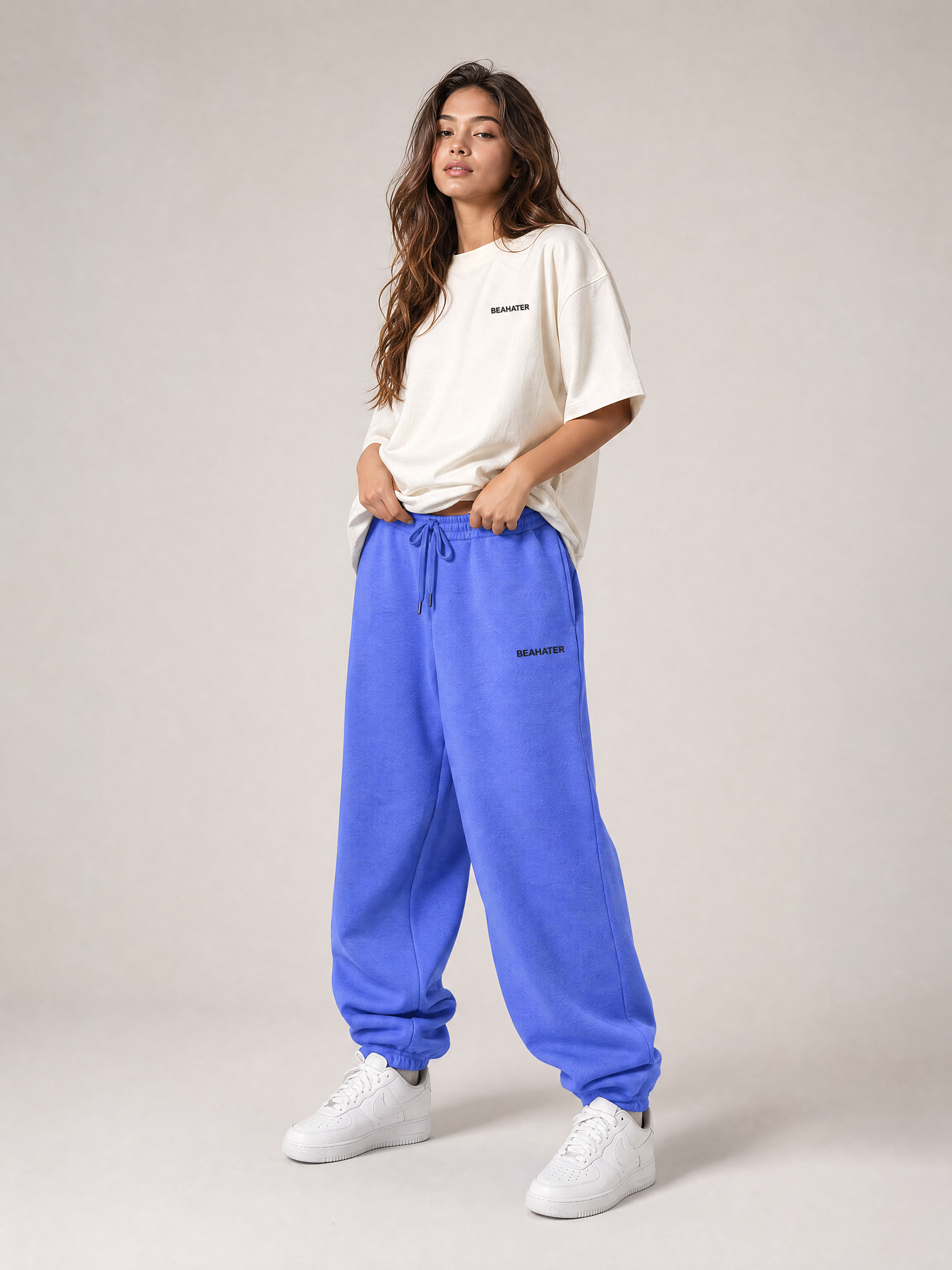 Baggy Jogger lila an weiblichem Model, Streetwear Look, weiter oversized Schnitt, weiße Sneaker