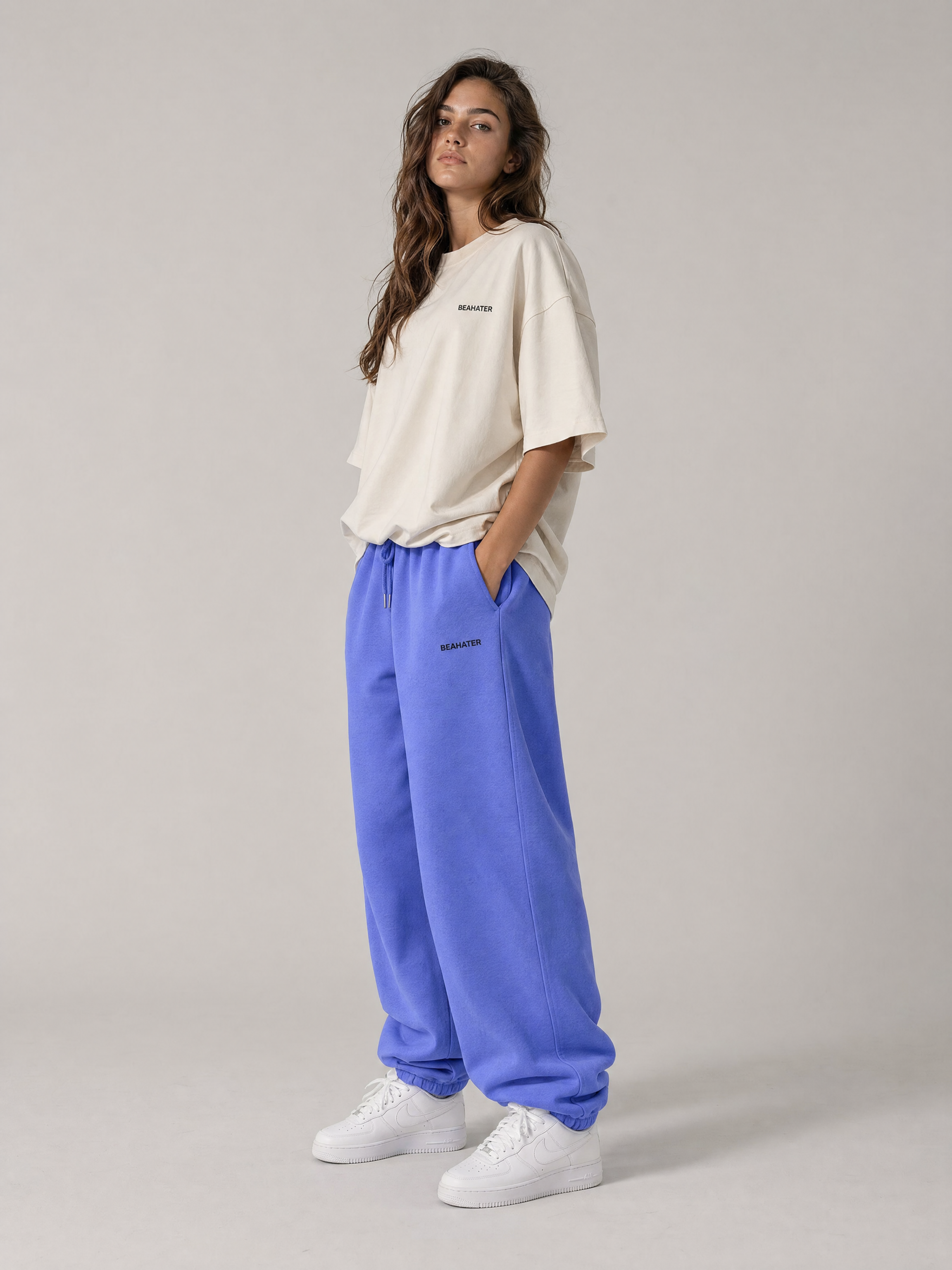 Baggy Jogger lila an weiblichem Model, Seitenansicht, weiter baggy Schnitt, weiße Sneaker