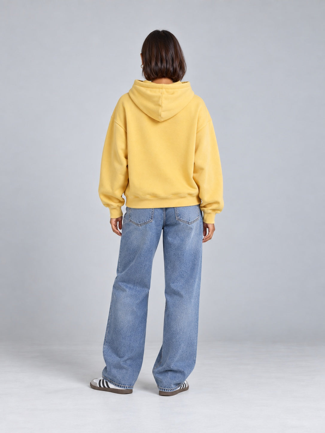 Rückansicht des gelben BEAHATER Oversized-Hoodies am weiblichen Model, ohne Rückenprint.