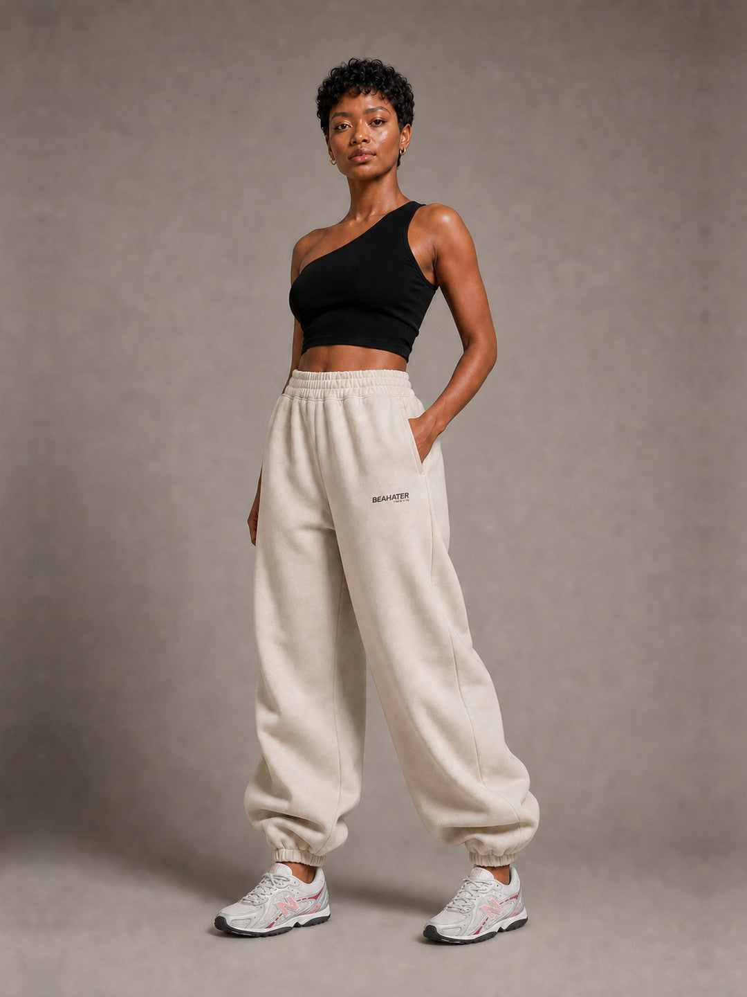 BEAHATER Relaxed Sweatpants Beige im Baggy-Fit – 3/4-Ansicht mit silber-weißen Retro-Sneakern