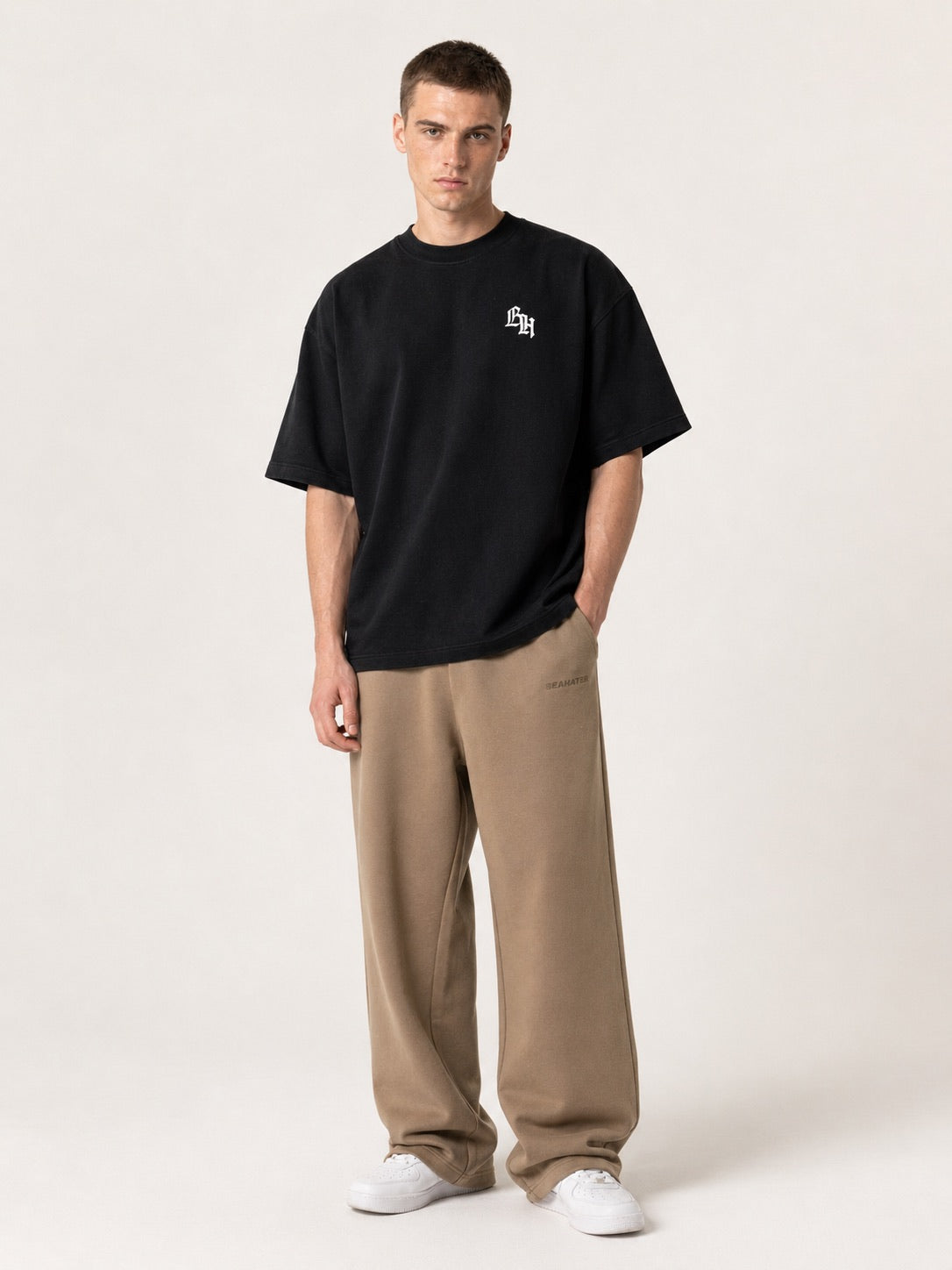 Schwarzes Oversized T-Shirt am Model mit kleinem BH-Logo Stick auf der Brust, Vorderansicht
