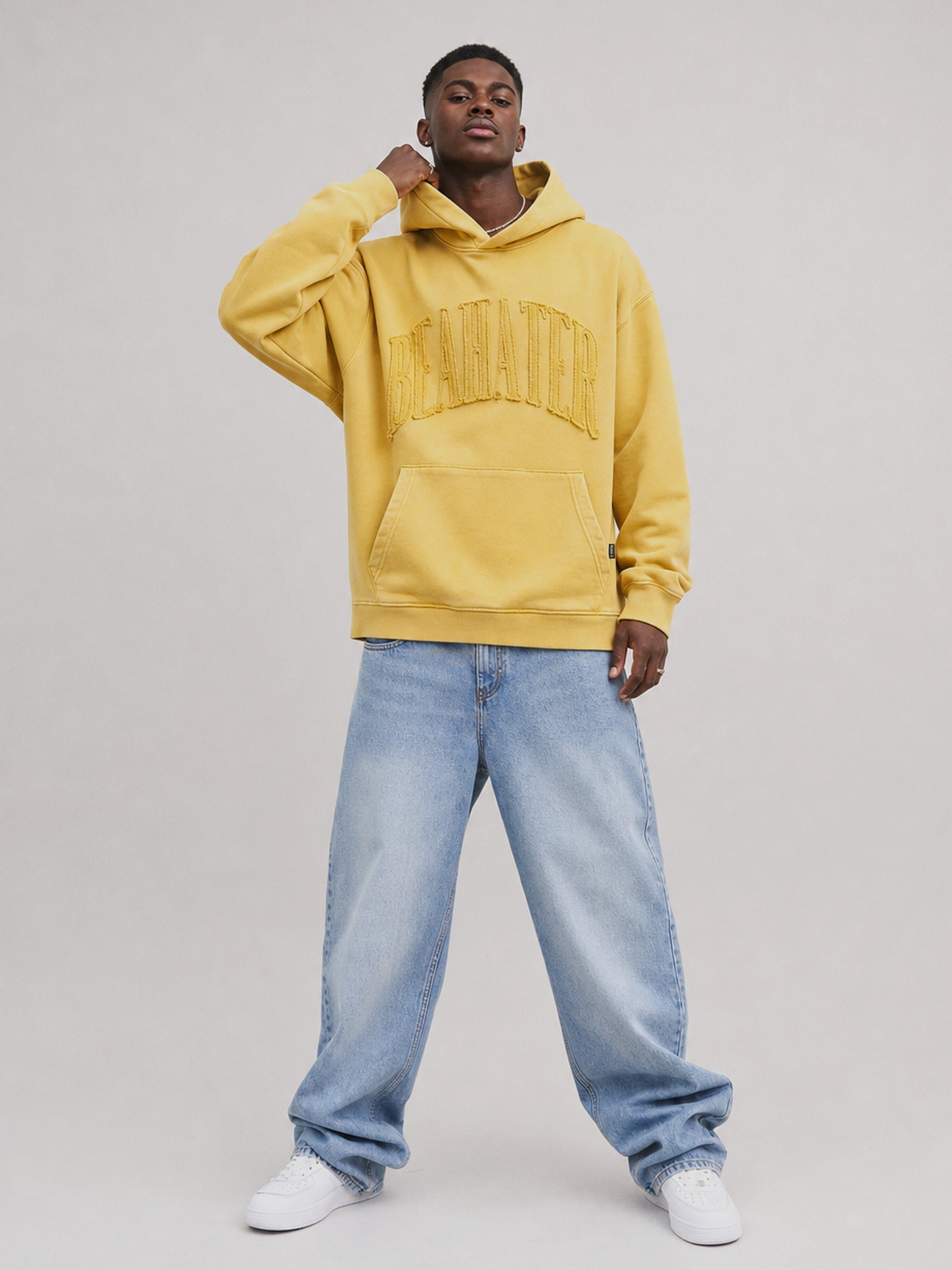 Oversized Hoodie in Mustard am männlichen Model, Washed Finish mit Kängurutasche, kombiniert mit heller Baggy Jeans