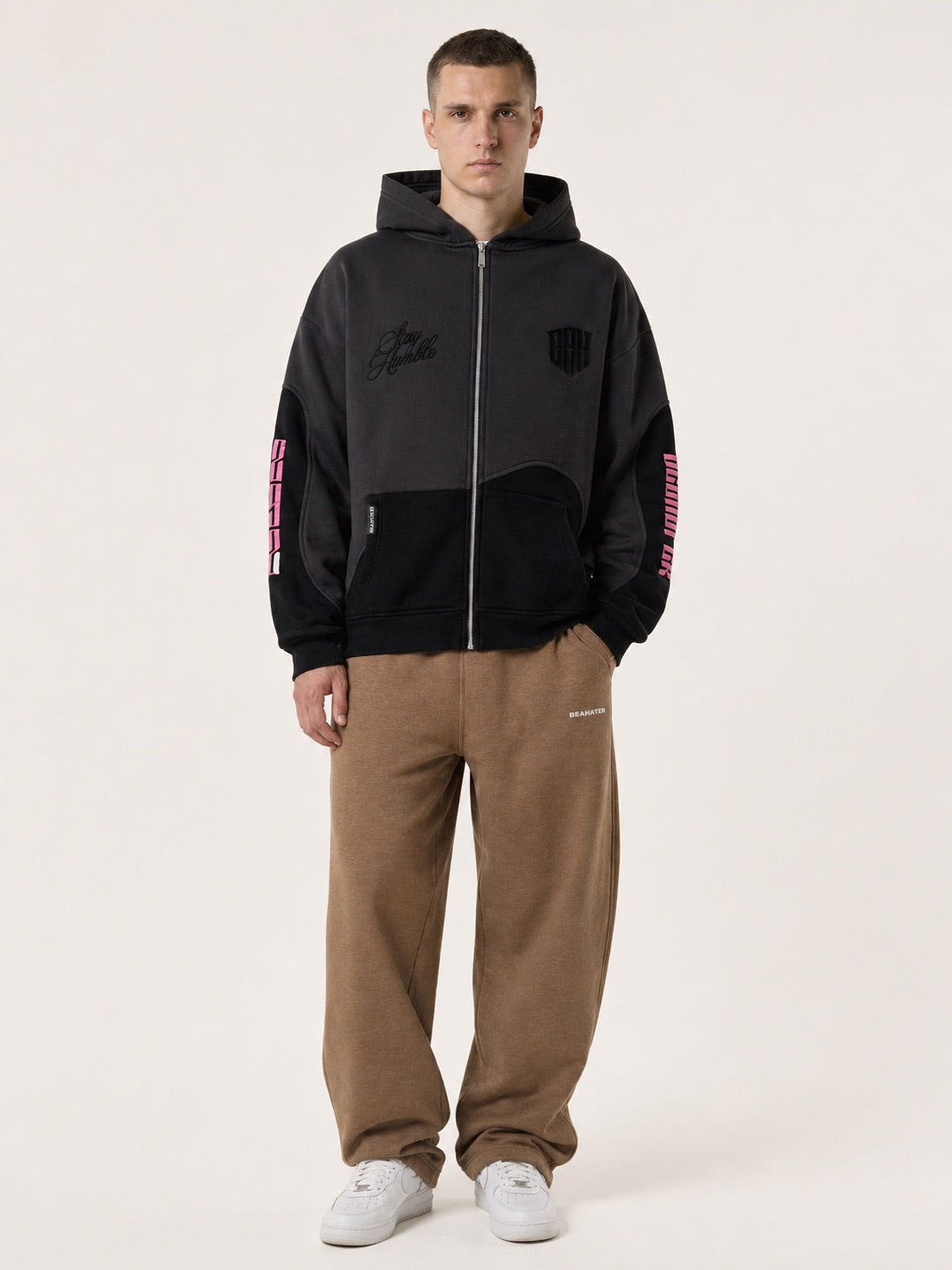 Schwarzer Zip Hoodie Oversized am Model, getragen mit brauner Sweatpant, Streetwear Outfit Vorderansicht